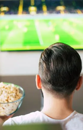 Un passionné de sport regarde un match de foot en direct sur IPTV